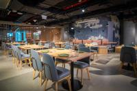a dining room with wooden tables and chairs at AUHotel -Zayed International Airport-Located in Transit Area -Onwards Boarding Pass Required in Abu Dhabi