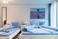 Un dormitorio con dos camas con almohadas azules. en HITrental Allmend Comfort Studios, en Lucerna