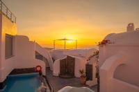 puesta de sol sobre el océano desde una casa con piscina en Sole d&#39;oro Luxury Suites, en Oia