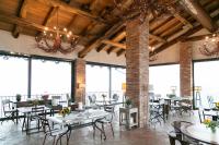 een eetkamer met tafels en stoelen en ramen bij Prime Alture Wine Resort in Casteggio