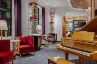 um átrio com um piano e cadeiras vermelhas em The Admiral, Downtown Historic District em Mobile