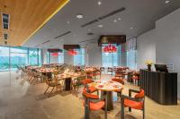 Un comedor con mesas y sillas y ventanas. en Poseido Hotel Quảng Bình, en Dong Hoi