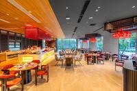 Un restaurante con mesas y sillas en una sala. en Poseido Hotel Quảng Bình, en Dong Hoi