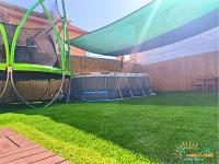 einen Garten mit einem Pavillon und grünem Gras in der Unterkunft Family-TIME בית פרטי לנופש משפחתי באילת in Eilat