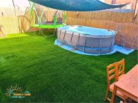 einen Whirlpool im Garten mit grünem Rasen in der Unterkunft Family-TIME בית פרטי לנופש משפחתי באילת in Eilat