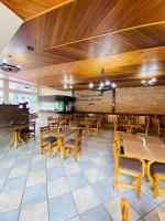 una sala da pranzo con tavoli e sedie in legno di Hotel Nazaré a Nazaré Paulista