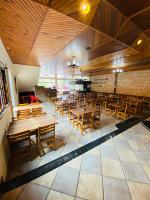 un ristorante vuoto con tavoli e sedie di legno di Hotel Nazaré a Nazaré Paulista