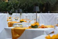a row of tables with wine glasses and yellow napkins at Hotel Virgilio in Riva del Garda