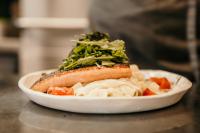 Un plato de comida con un perrito caliente y verduras. en Wirt Weissau, en Oberweißau