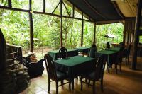 Un restaurante con mesas y sillas y un oso tirado en el suelo. en Chilamate Rainforest Eco Retreat, en Puerto Viejo