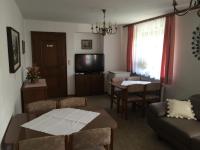 sala de estar con sofá, mesa y TV en Landhaus Moises, en Bad Hofgastein