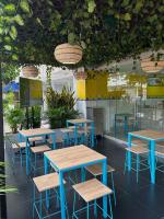 a cafeteria with blue tables and chairs and plants at Hotel Sun Suite in Barranquilla