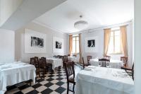 a dining room with white tables and chairs and windows at Cascina Marchesa in Turin