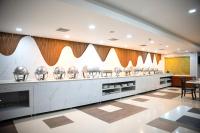 un ristorante con una fila di piatti d'argento di Heritage Residency By Lemongrove Hospitality a Madurai