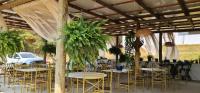a banquet hall with tables and chairs and plants at Pousada Descobrindo a Vida in Brumadinho