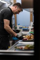 a man preparing a plate of food in a kitchen at Hotel Nice in Laupheim