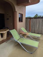 two green lounge chairs and a table on a porch at Casa Arcoiris Zihuatanejo B&B in Zihuatanejo