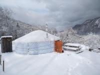 a yurt is covered in snow in a field at Yourtes Olachat proche Annecy in Faverges