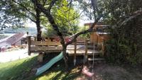 a tree house with a swing in a tree at Yourtes Olachat proche Annecy in Faverges