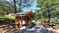 a small wooden building with a table and benches at Yourtes Olachat proche Annecy in Faverges