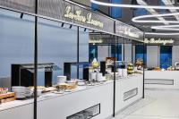 una línea de buffet con comida expuesta en una tienda en H4 Hotel Wyndham Paris Pleyel Resort, en Saint-Denis