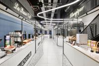 una tienda de comestibles con mostradores blancos y un pasillo largo en H4 Hotel Wyndham Paris Pleyel Resort, en Saint-Denis