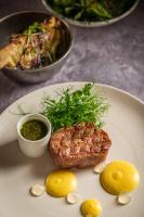 een bord met eten, een stuk biefstuk en citroenen bij TIZÓN Suites in Garachico