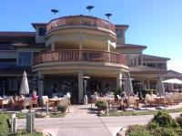 a large building with people sitting at tables and umbrellas at Premium Villa - Ocean View - SEASCAPE - Heated 80 Degree Pools - Relaxing Fireplace - Ground Level in Aptos