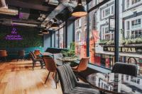 Un restaurante con mesas, sillas y ventanas. en Kabannas Liverpool, en Liverpool