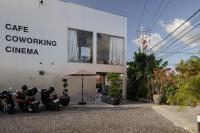 un edificio blanco con motocicletas estacionadas frente a él en Unit Space Village, en Canggu