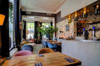 een restaurant met tafels en stoelen en een bar bij Appartement Nu in Eersel