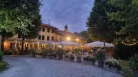 a restaurant with tables and umbrellas in front of a building at Pra' Grande in Fossalta di Portogruaro