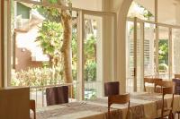 a dining room with a table and a large window at Hotel Saraceno Resort with Private Beach in Milano Marittima