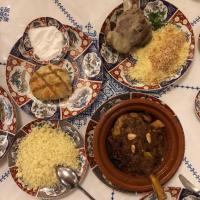 a table topped with plates of food with meat and rice at Riad Al Fassia Palace in Fès