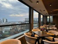 Un restaurante con mesas y sillas y un gran ventanal. en Lumière Hotel Pool & SPA, en Belgrado