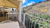 a balcony with a table and chairs and a mountain at Histórica Casa con vistas al Jardín de Cactus y montañas in Mogán