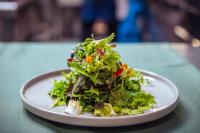 a white plate with a salad on a table at Hotel Balcó del Priorat in La Morera de Montsant