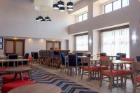Un comedor con mesas y sillas y ventanas. en Hampton Inn &amp; Suites Riverton, en Riverton