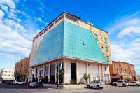 a glass building with cars parked in front of it at Banan Hotel & فندق بنان in Tabuk