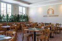 une salle à manger avec tables, chaises et plantes dans l'établissement Hotel Monsenhor, à São Sebastião do Paraíso