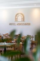 un restaurant avec des tables et des chaises et un panneau hotelmonster dans l'établissement Hotel Monsenhor, à São Sebastião do Paraíso