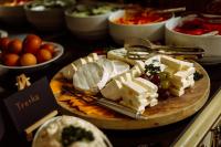 um prato de queijos e outros alimentos sobre uma mesa em Hotel Most Slávy em Trenčianske Teplice