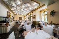 uma sala de jantar com mesas e cadeiras brancas em Hotel Most Slávy em Trenčianske Teplice