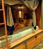 una mujer sentada en una litera leyendo un libro en Mediterraneo Youth Hostel, en Asunción
