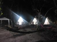 a group of tents with lights in the dark at Camping rock in Itanhaém