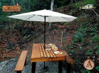 uma mesa com um guarda-chuva e pratos de comida em Magno Glamping Valle de Tenza em Boyacá