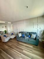 ein Wohnzimmer mit einem blauen Sofa und Holzböden in der Unterkunft Luxe by the Sea - 5-Star Beachfront Escape in Myrtle Beach