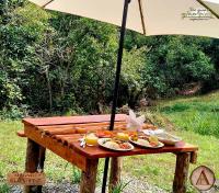 uma mesa de piquenique com comida e um guarda-chuva em Magno Glamping Valle de Tenza em Boyacá