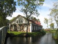 an old house on the side of a river at Bistrampolis Manor in Kučiai