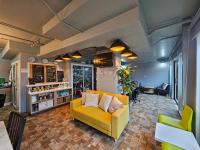 Plus 2 Condo Phuket by ABCD في كاتو: غرفة معيشة مع أريكة صفراء وكراسي